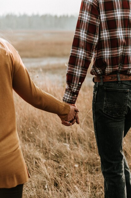 Couple holding hands in a field