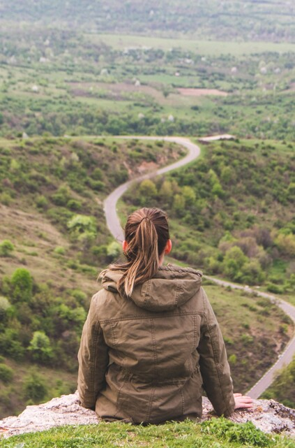 Woman looking out over a valley road