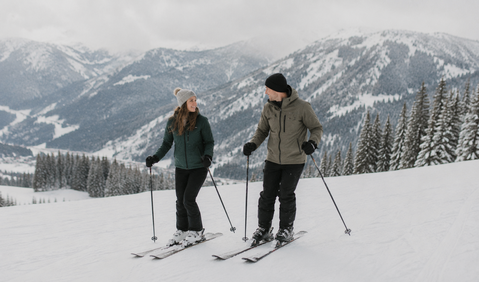 Couple skiing together on a snowy mountain